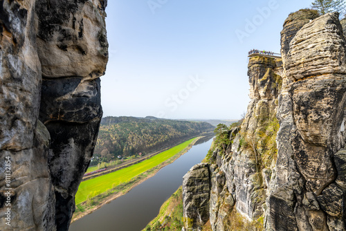 Overlooking the serene Elbe River from the iconic Bastei rock formation in Saxon Switzerland National Park, Germany, on a clear spring day.