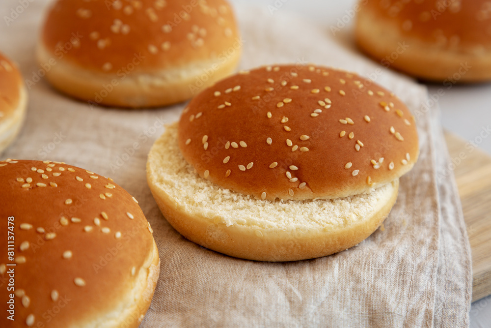 Classic Sesame Seed hamburger Buns on a Wooden Board, side view. Classic Sesame Seed hamburger Buns on a Wooden Board, side view.
