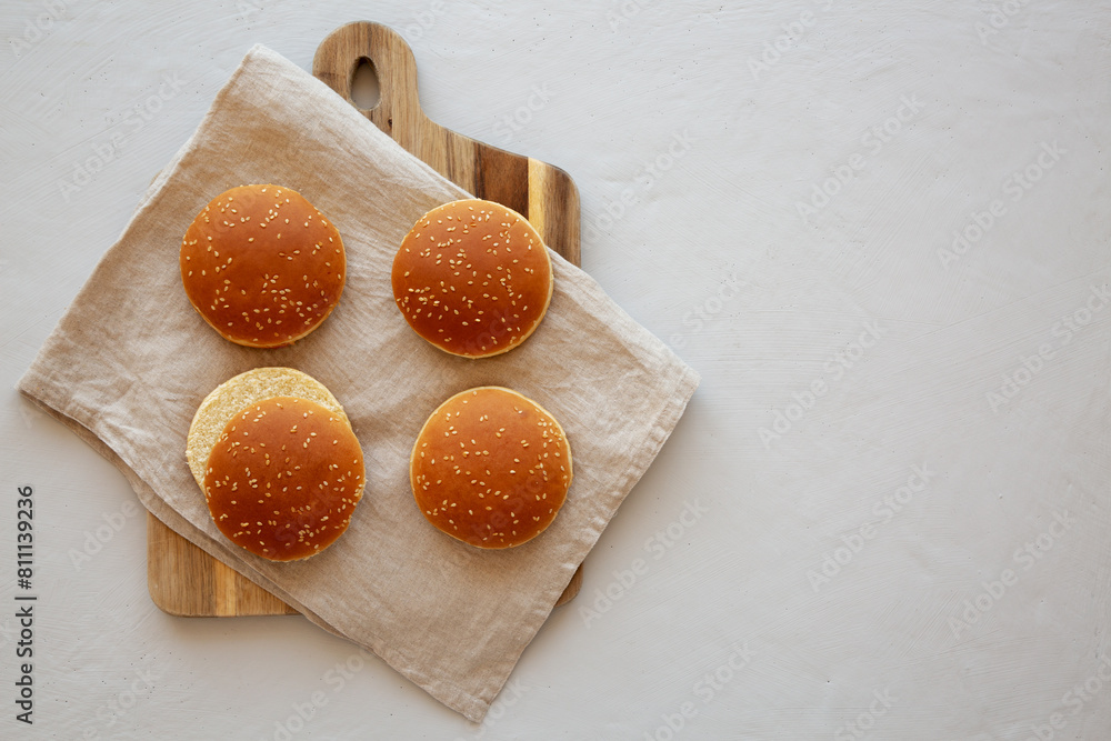 Classic Sesame Seed hamburger Buns on a Wooden Board, top view. Copy ...