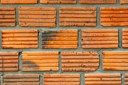 Closeup view of old grunge red brick wall background. The  old wall of grooved bricks with cement.