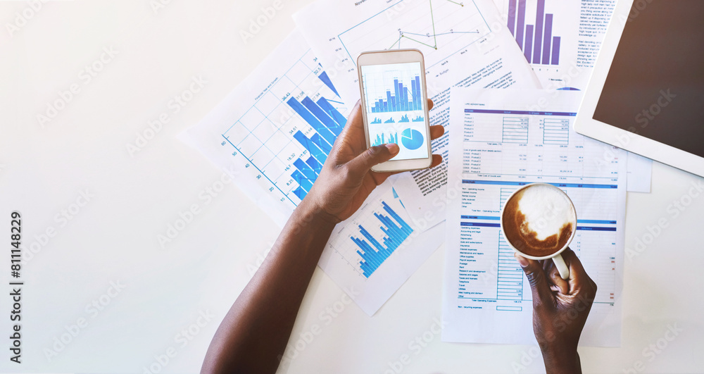 Phone screen, paperwork and hands of person with charts, graphs and statistics for productivity in office. Data analysis, mobile app and consultant with coffee, documents and smartphone from above