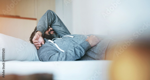 Tired, sleep and man in bed with stress, burnout and mental health rest in home, apartment or hotel. Fatigue, insomnia and person with depression, anxiety or headache in bedroom to relax in morning © peopleimages.com