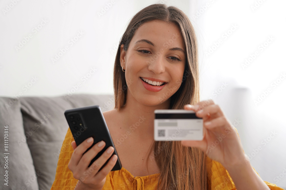 Close-up of hispanic woman reading credit card number for online shopping at home Close-up of hispanic woman reading credit card number for online shopping at home