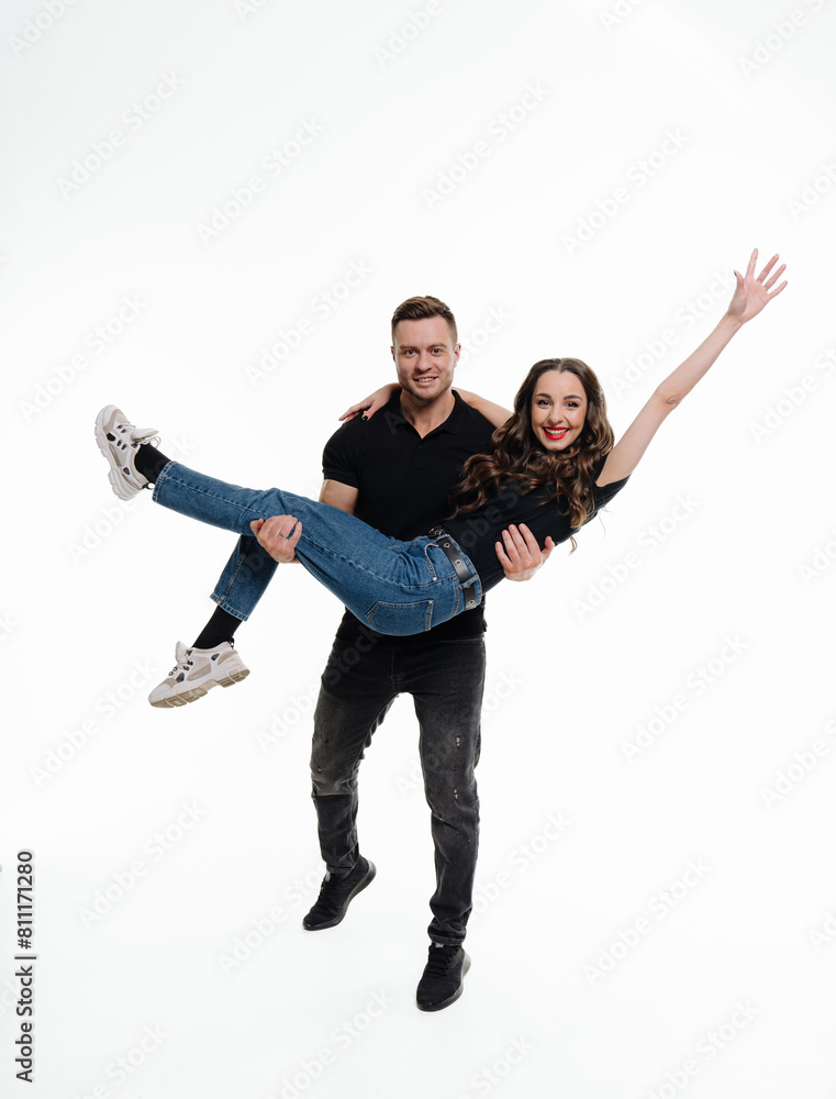 A man and a woman are posing for a picture, with the woman being lifted by the man. A man and a woman are posing for a picture, with the woman being lifted by the man.