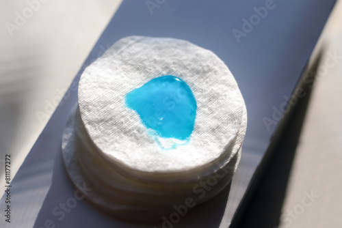 A sponge with a transparent blue gel applied to it. Close-up. Blurred background.