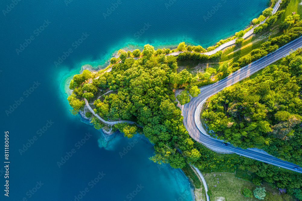 Aerial View of Lago di Ledro with Turquoise Water and Winding Road, Vibrant Summer Landscape in Northern Italy, Scenic Lakeside Route