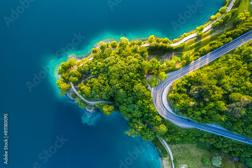 Obraz na płótnie Aerial View of Lago di Ledro with Turquoise Water and Winding Road, Vibrant Summer Landscape in Northern Italy, Scenic Lakeside Route w salonie
