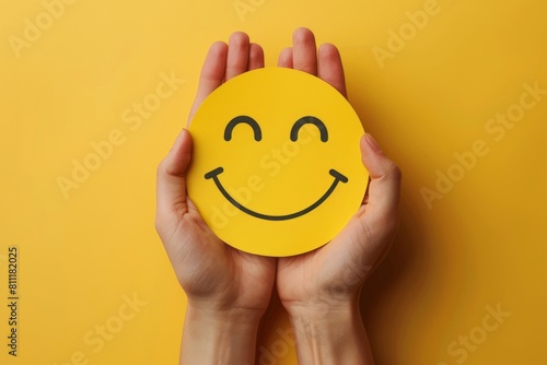 Two hands holding yellow paper smiley face on solid yellow background . ai generated