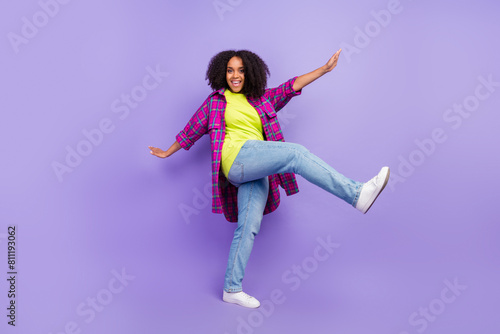 Full size photo of pretty young girl dancing step wear trendy plaid outfit isolated on purple color background