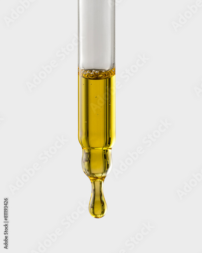 Cosmetic pipette with a drop close-up on a gray background