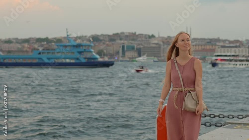 Immersed in the vibrant ambience of Galataport, a young woman tourist takes in the charm of Istanbul with a joyful stroll along the pier. photo