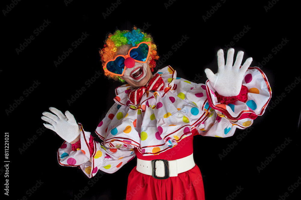Funny clown in the circus, man entertainer as Joker in a suit and wig, with clown whiteface makeup. Trickster, jester, pantomime, mime, and a professional actor at events Funny clown in the circus, man entertainer as Joker in a suit and wig, with clown whiteface makeup. Trickster, jester, pantomime, mime, and a professional actor at events