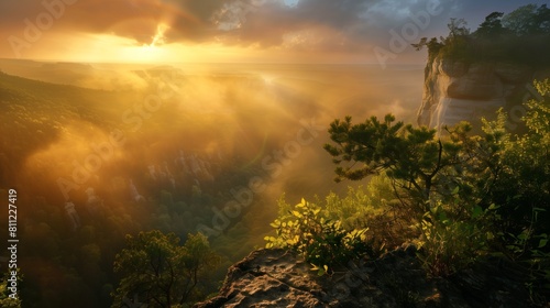 dramatic sunrise over misty forest and rugged cliffs bathed in golden morning light