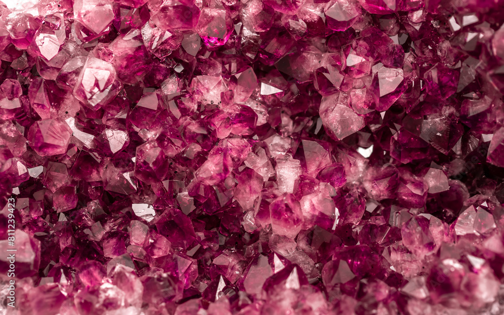 Amethyst garnet crystals. Burgundy gemstone. Mineral crystals in the natural environment. Texture of precious and semiprecious stones. Colored shiny surface of precious stones.