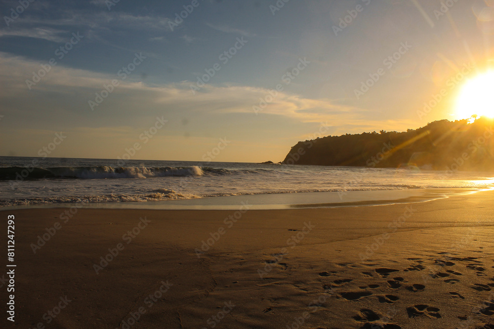 Beautiful sunset over the sea or sea. Bright and soft colors, magic light. Small clouds in the sky, reflection of the sun in the water and sand on the beach. Concept of romantic time on vacation in th Beautiful sunset over the sea or sea. Bright and soft colors, magic light. Small clouds in the sky, reflection of the sun in the water and sand on the beach. Concept of romantic time on vacation in th
