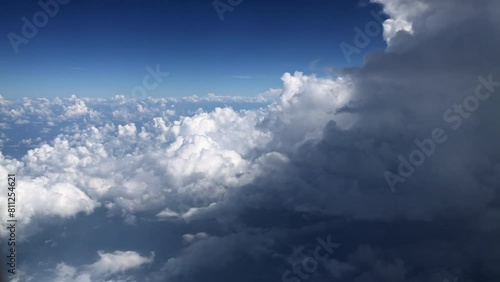 Aerial view of cumulus cloudscape from airplane window against blue sky photo
