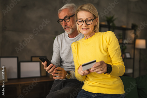 Mature caucasian couple husband and wife shopping online sit at home