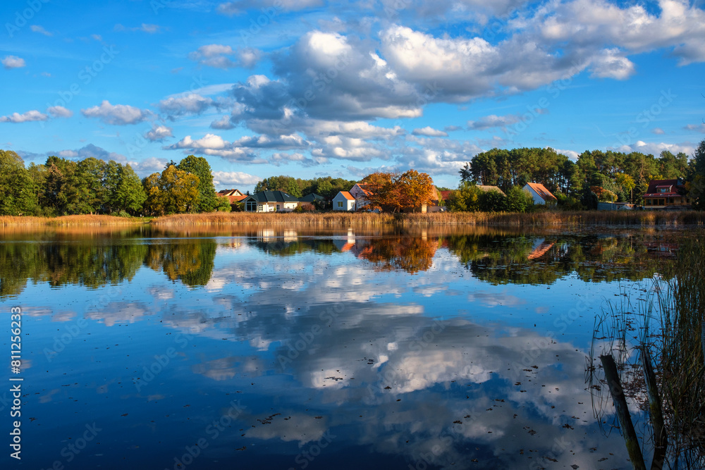Natural landscape of the lake, high definition, the movement of waves against the background of the autumn forest. The reflection of clouds on the ripples of water. Germany.