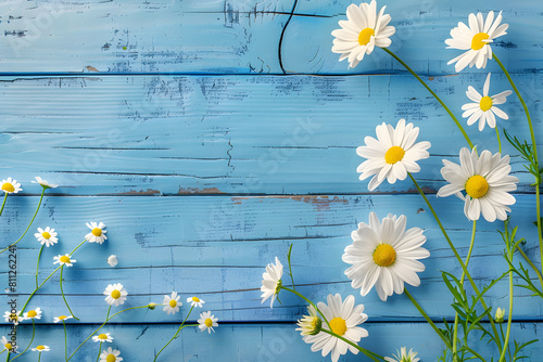 Daisy flowers on light blue shabby wooden background  for mockup. Painted teal old rustic wooden table with daisies. Top view, flat lay. Abstract texture with copy space for banner, mockup, poster