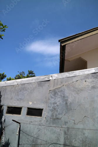 view of a house roof and walls with a view of the bright blue sky