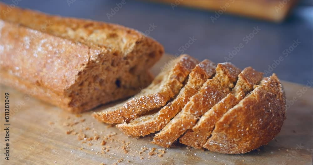 Sliced ​​baguette of dark buckwheat bread on a wooden cutting board