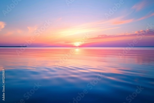 The sun is setting over calm water  creating a beautiful blue sky reflection  A peaceful sunset over the calm waters  reflecting various shades of orange and pink