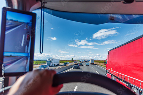 Overtaking from one truck to another on a highway crowded with vehicles, seen from inside the truck that is traveling faster.