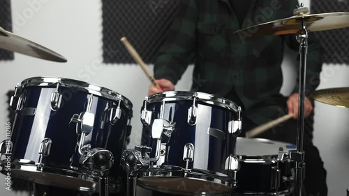 Close-up of an adult drummer playing a blue drum kit in a studio. photo