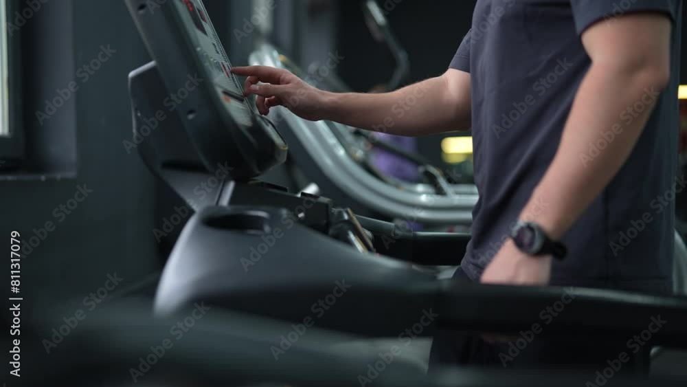 Cropped shot of unrecognizable athletic man walking on treadmill preforming warming-up run routine exercise in gym. Sporty male with fitness tracker walking on treadmill, working on health and fitness Cropped shot of unrecognizable athletic man walking on treadmill preforming warming-up run routine exercise in gym. Sporty male with fitness tracker walking on treadmill, working on health and fitness
