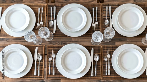 a dining table setting from above, featuring a pristine white plate, sleek cutlery, and a black place mat on a warm wooden surface, offering ample copy space for text or design.