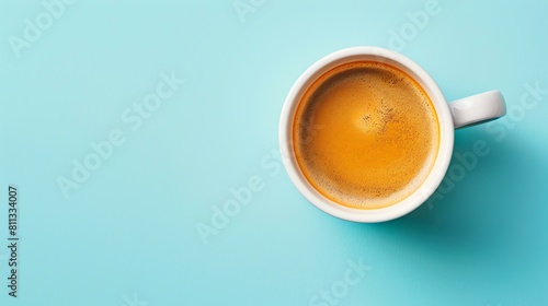 Freshly brewed coffee in a white cup on a blue background. Top view. photo
