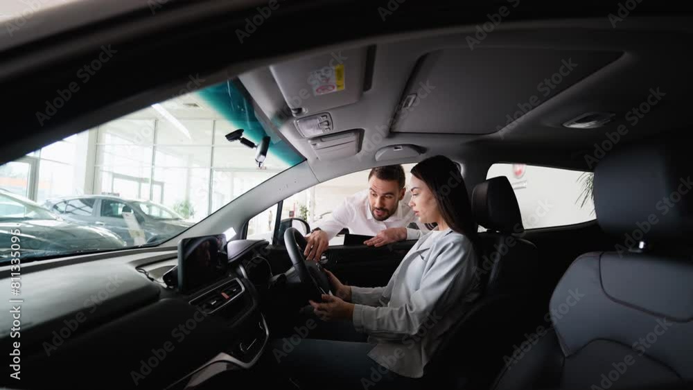 Car seller helps a female client choose a new car. Right hand drive car Car seller helps a female client choose a new car. Right hand drive car