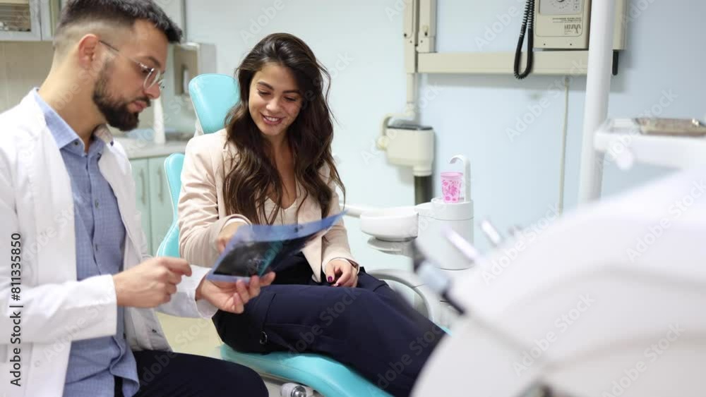 Dentist showing the x-ray to his patient Dentist showing the x-ray to his patient
