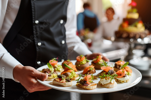 Vertical. A variety of gourmet appetizers: canape sandwiches on an elegant restaurant tray.