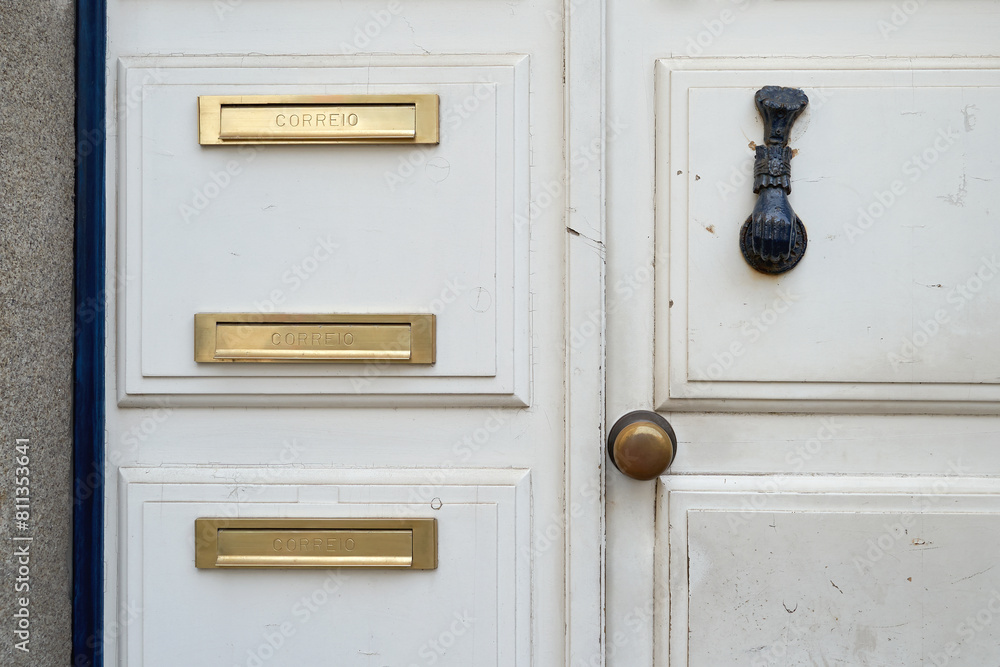 Letter box aka letterbox, letter plate, letter hole, mail slot, or mailbox. Old white vintage door with a knocker in Portugal. Letter box aka letterbox, letter plate, letter hole, mail slot, or mailbox. Old white vintage door with a knocker in Portugal.
