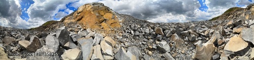 Obraz na płótnie Carpathian Mountains of Ukraine, a quarry where granite sandstone is mined for the production of building materials, powerful trucks and conveyors load gravel - video from a drone w salonie