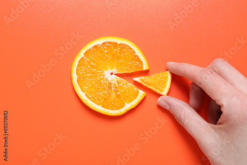 Woman with slices of juicy orange on terracotta background, top view