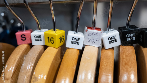 Wooden clothes hangers with coloured size cubes including one size in a retail fashion shop