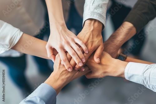 A close-up of a diverse group of people stacking hands as a symbol of teamwork and unity