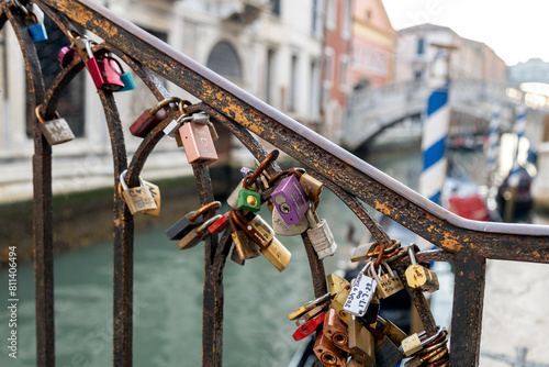 Love locks attached to rusty bridge railing over canal in Venice, Italy