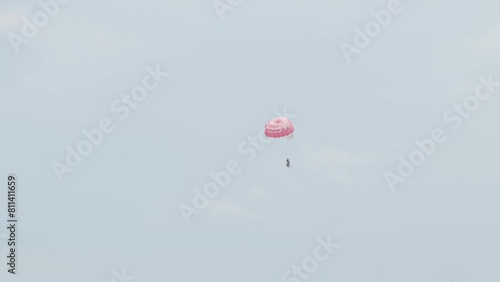 people on a parachute flying in the sky, on cable, slow motion
 photo