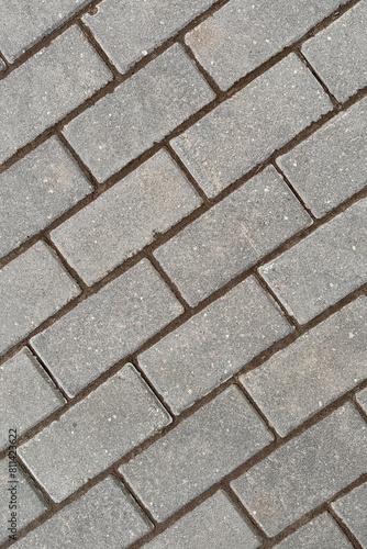 Detailed closeup of a grey rectangular brick wall showing intricate brickwork pattern. Made of composite material resembling concrete. Ideal for road surface or flooring design
