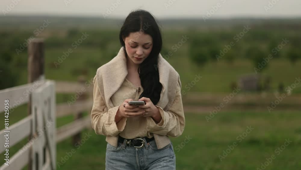Charming stylish young woman using social media application on smartphone scrolling texting messages receive news at countryside village Happy female texting enjoying leisure time outdoors Charming stylish young woman using social media application on smartphone scrolling texting messages receive news at countryside village Happy female texting enjoying leisure time outdoors