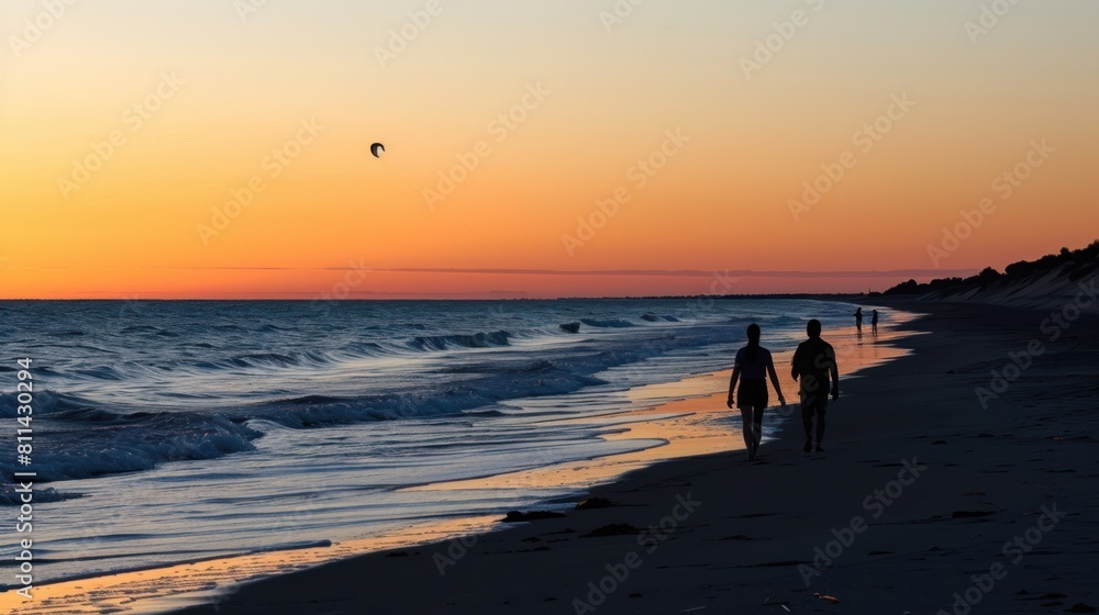 A couple walking on the beach at sunset