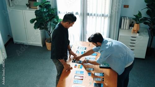 Top view of front-end developer design Ux Ui design for mobile phone interface with multicultural team. Professional smart designer walking and joining meeting while planning application. Convocation. photo