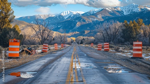 Detailed shot of a country road closure for construction, rocky mountains in the distance, clear bright lighting highlighting the scene photo