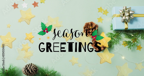 Image of season greetings text and stars over presents and decorations