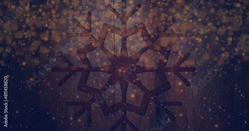 Image of snow falling and light spots over snowflake on wooden background