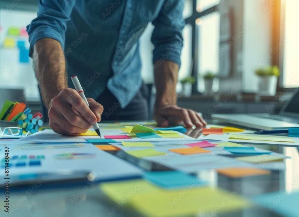 Obraz premium Businessman making a plan using sticky notes on his desk in his office, in the style of a Business data analysis concept.