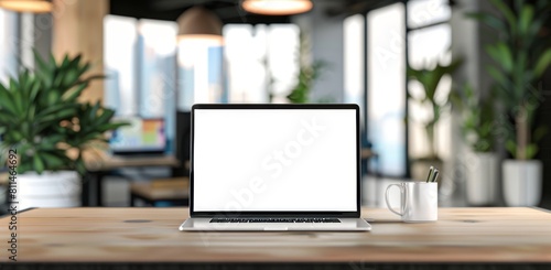 Laptop with blank screen on wooden desk in a blurred office interior background, in the style of a banner design. © DWN Media